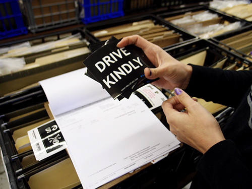 Custom square shaped stickers that say Drive Kindly, originally printed by StickerGiant