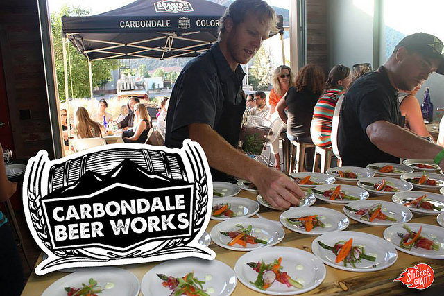 Die-Cut-Logo-Sticker-for-Carbondale-Beer-Works-with-Food-Tent-in-Background-stickers-printed-by-StickerGiant