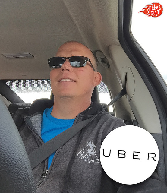 John-Fischer-CEO-of-StickerGiant-in-a-car-to-show-the-custom-circle-sticker-printed-for-Uber