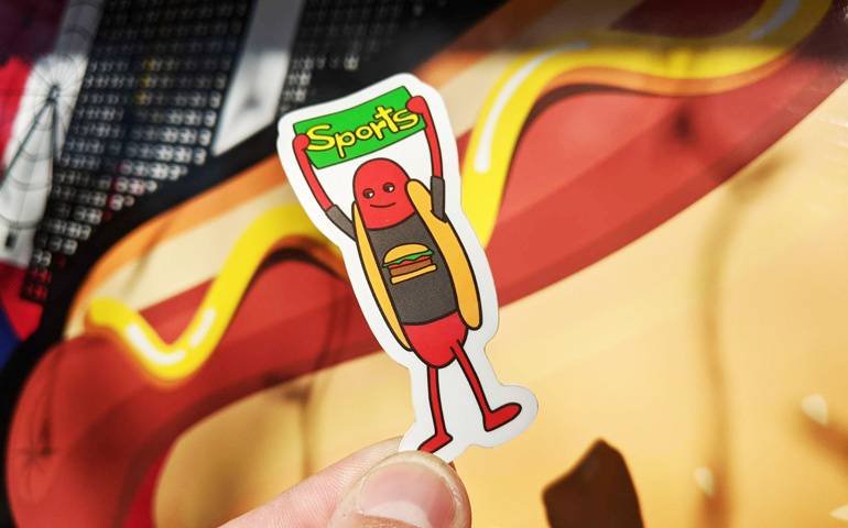 Die-Cut-Sticker-of-Hot-Dog-Holding-Sports-Sign-for-Haha-Hot-Dogs-and-Printed-by-StickerGiant