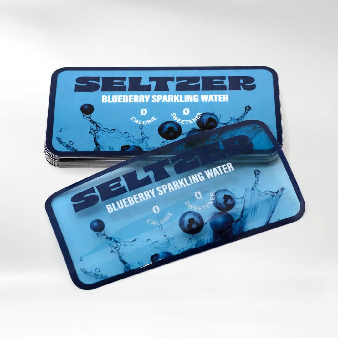 Stack of Seltzer Blueberry Sparkling Water custom clear stickers showing a transparent material with vibrant full color printing.