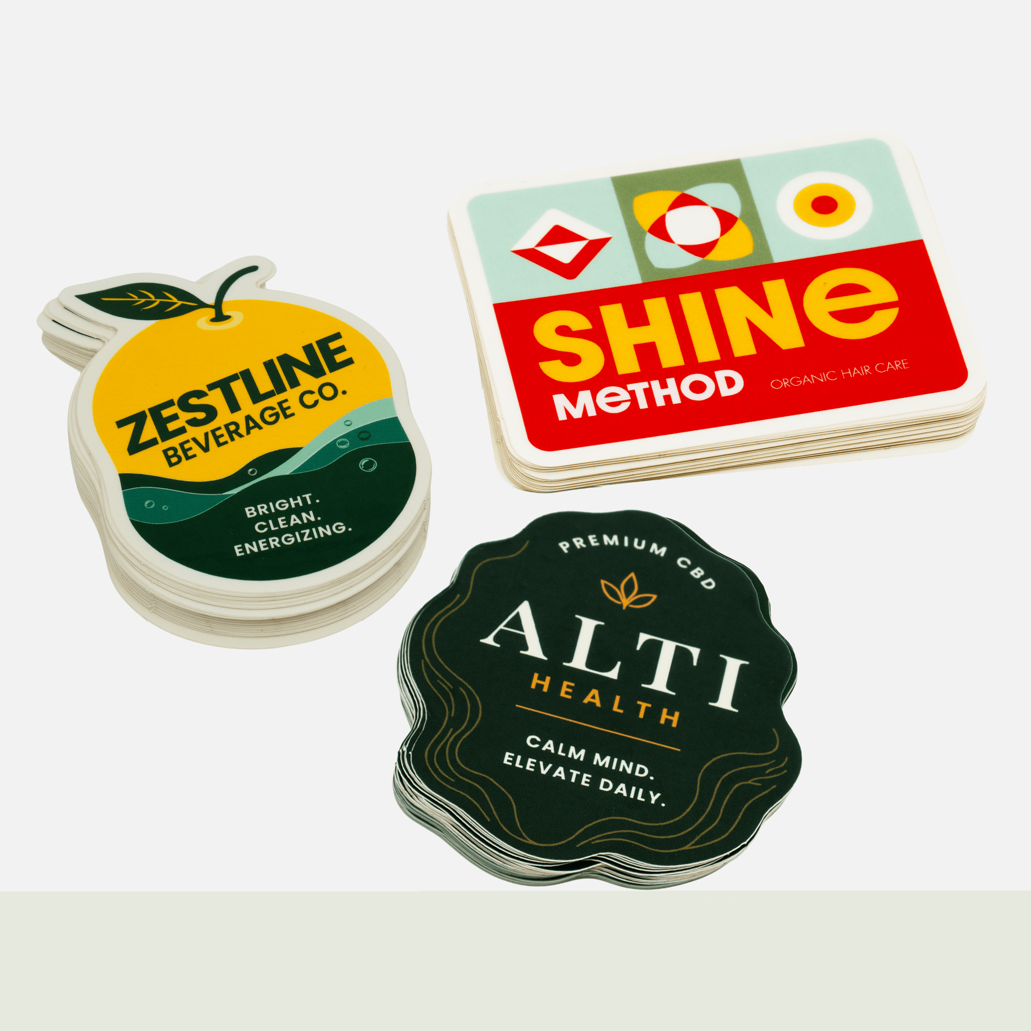 Custom die cut stickers in unique shapes and sizes featuring beverage, beauty, and wellness branding with vibrant full color printing.