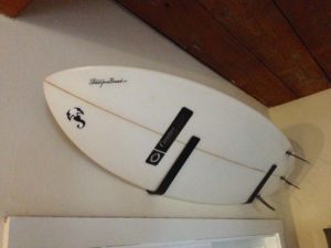 Surf-Board-on-a-Wall-Rack-from-StoreYourBoard.com-with-a-Custom-Sticker-Printed-at-StickerGiant