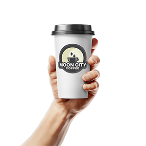 A hand holding a to go coffee cup with Moon City label printed by StickerGiant applied to the side of the cup