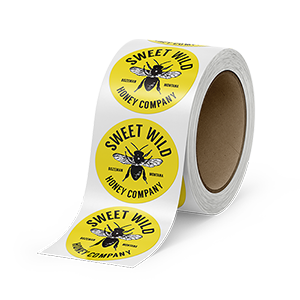 A roll of circle labels printed by StickerGiant with Sweet Wild Honey Company logo printed on them 