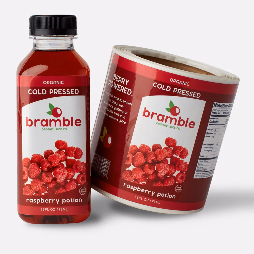 A roll of glossy labels printed by StickerGiant with a bottle of juice with the Bramble cold pressed juice glossy label applied to the bottle
